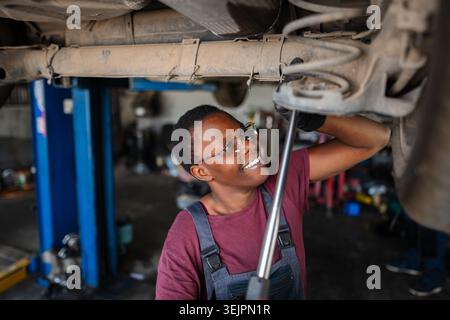 Young female african mechanic repairing car in a workshop Stock Photo