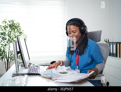 Healthcare worker using headset and reading medical documents Stock Photo