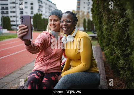 Diverse women friends taking selfie after workout Stock Photo