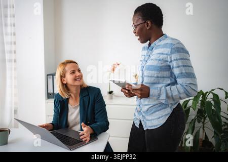 Businesswomen collaborating on project in modern office Stock Photo