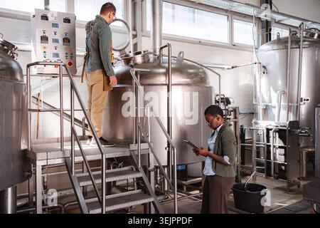 Factory workers checking manufacturing process in a modern craft beer brewery Stock Photo