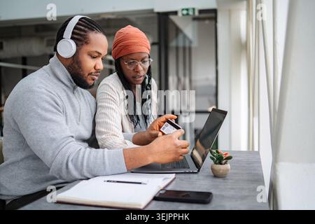 Couple shopping online using laptop and credit card Stock Photo