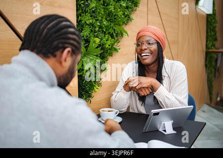 Diverse colleagues laughing enjoying coffee during business meeting Stock Photo
