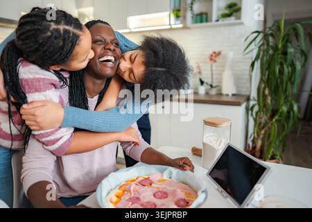 Happy family bonding in kitchen making pizza together Stock Photo