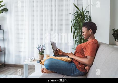 Young Woman Working From Home on Laptop Stock Photo