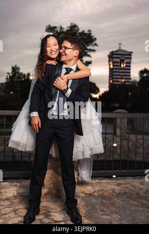 Happy bride and groom celebrating their wedding day, embracing with smiles Stock Photo