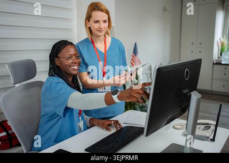 Healthcare professionals collaborating on computer using digital tablet Stock Photo