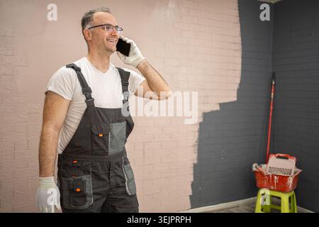 Man in Overalls Talking on Cell Phone Stock Photo