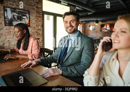 Diverse business people collaborating in a cafe or office setting Stock Photo
