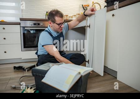 Handyman assembling kitchen cabinet in new home Stock Photo