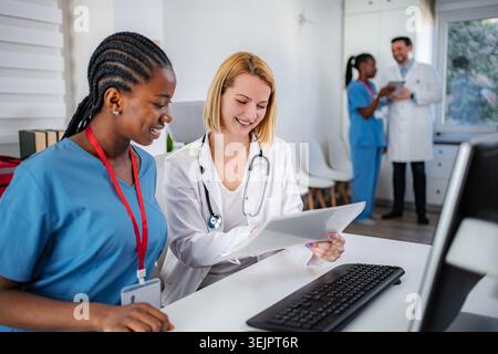 Medical professionals collaborating on documents in clinic office Stock Photo