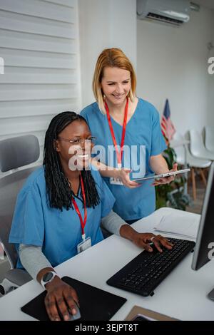 Healthcare professionals collaborating on computer using digital tablet Stock Photo