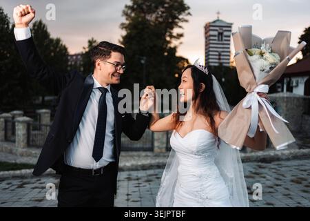 Happy multicultural wedding couple dancing celebrating marriage Stock Photo