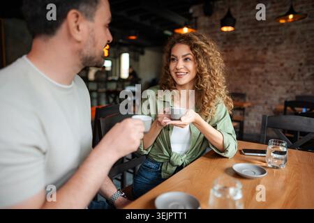 Young couple drinking coffee and talking in a cafe Stock Photo