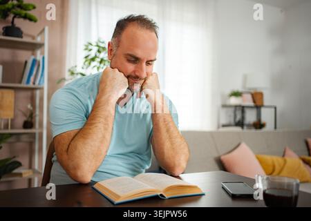 Man relaxing at home reading book with coffee Stock Photo