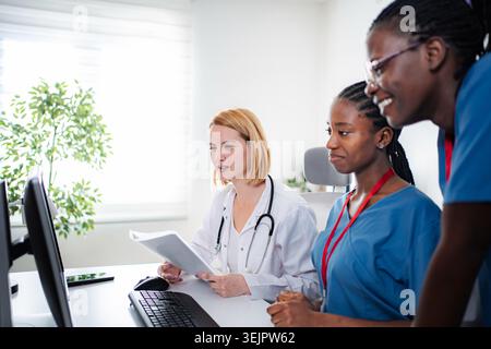 Medical team collaborating on computer in modern office Stock Photo