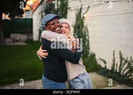 Happy young couple embracing outdoors on a chilly afternoon Stock Photo