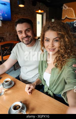 Young couple taking a selfie while having coffee in a cafe Stock Photo