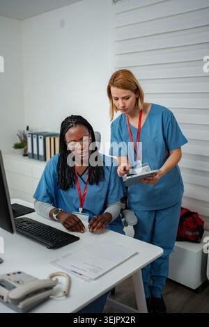 Nurses discussing data while working in a hospital office Stock Photo