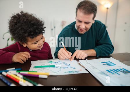 Father son bonding drawing together at home Stock Photo