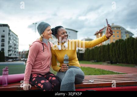 Diverse women friends taking selfie after outdoor workout Stock Photo