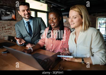Diverse startup team collaborating on business strategy using laptop Stock Photo