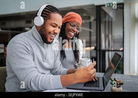 Happy black couple online shopping using credit card and laptop Stock Photo