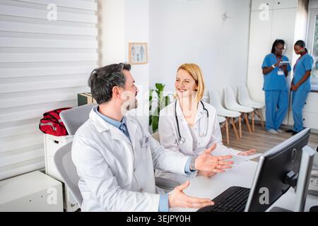 Medical professionals collaborating in hospital office discussing patient case Stock Photo