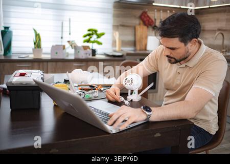 Technician installing surveillance camera using laptop at home Stock Photo