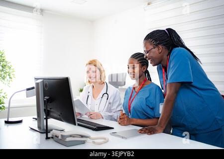 Medical professionals collaborating on computer in healthcare office Stock Photo