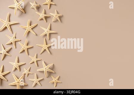 Starfishes on beige background as sand. Summer beach vacation. Stock Photo
