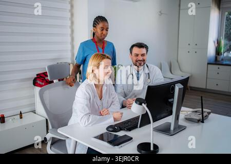 Medical team collaborating on computer in clinic office Stock Photo