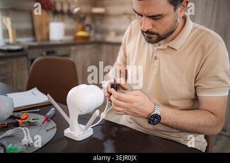 Man installing a new wireless surveillance camera at home Stock Photo