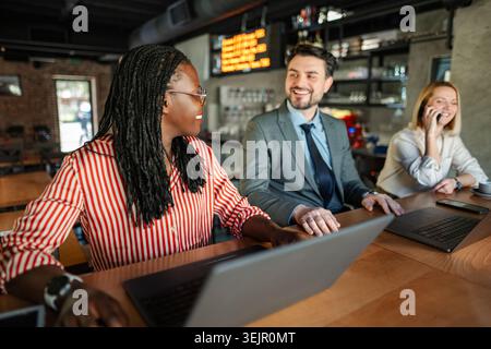 Diverse business team collaborating and networking in a modern cafe Stock Photo