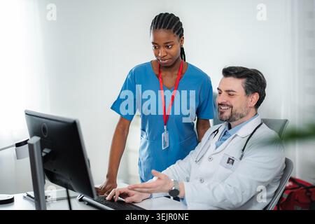 Healthcare professionals discussing patient data on a computer Stock Photo