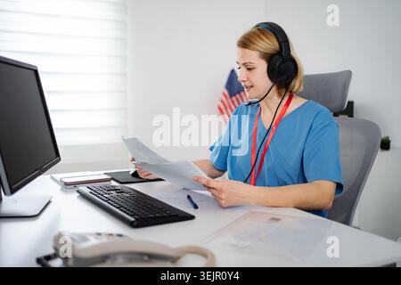 Healthcare professional working on computer during telehealth consultation Stock Photo