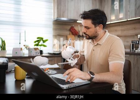 Technician installing surveillance camera using laptop at home Stock Photo