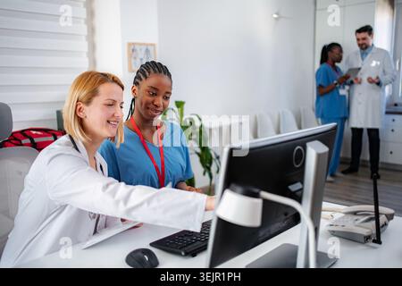 Medical professionals collaborating on computer in clinic office Stock Photo