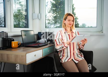 Woman freelancer working from home using digital tablet technology Stock Photo