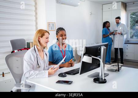 Diverse medical team collaborating in modern hospital office Stock Photo