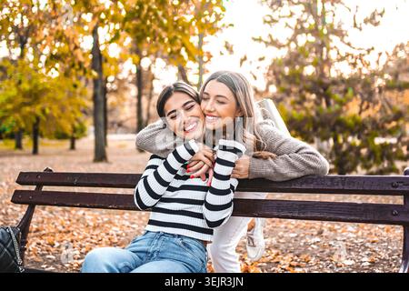 Two Women hugging on a Park Bench Stock Photo