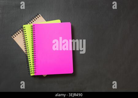 Colorful school supplies on black chalkboard. Top view, flat lay. Stock Photo