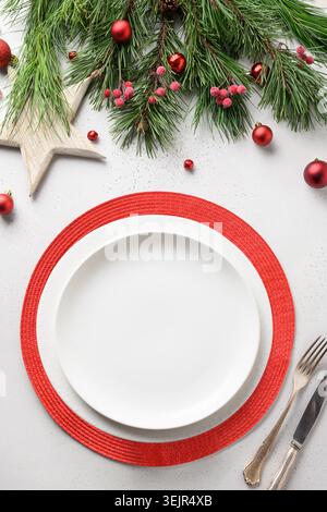 Christmas festive table setting with white and red holiday elegant decorations on white. Stock Photo
