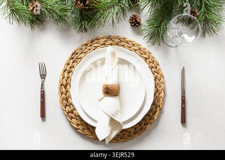 Christmas table setting with white holiday elegant decorations on white table. View from above. Stock Photo