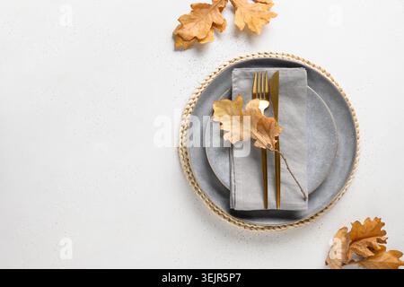 Autumn table setting with dry leaves and gray plate. Stock Photo
