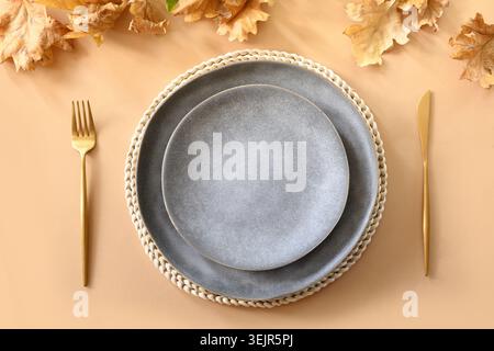 Fall table setting with autumn oak leaves and golden cutlery. Stock Photo