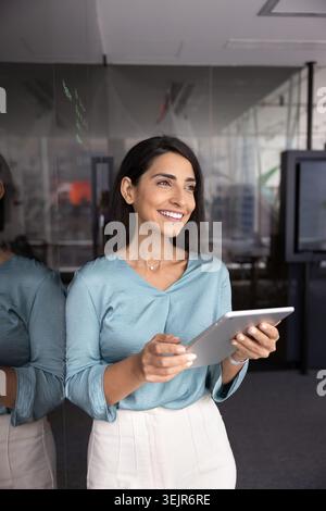 Smiling businesswoman using digital tablet in office Stock Photo