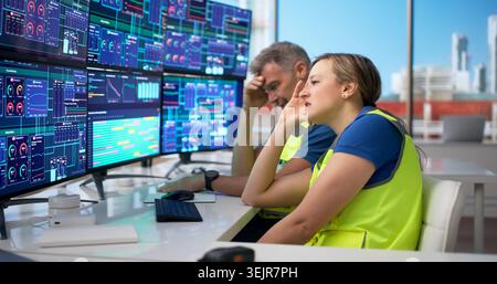 Two Engineers Working Late At Refinery Plant, Feeling Tired And Stressed. Stock Photo