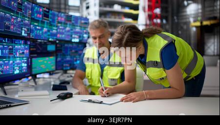 Two Engineers Discuss Project Details While Handing Over Shift At Aerospace Lab. Stock Photo