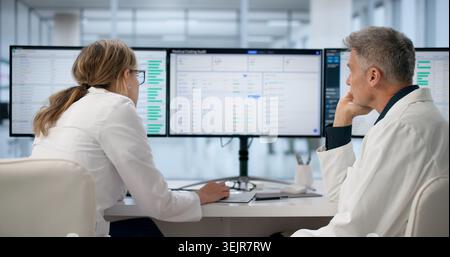 Hospital Administrator Frowns While Reviewing Stressful Medical Billing Spreadsheets. Stock Photo